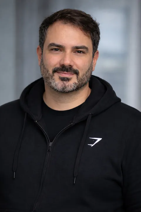 Guilherme de Mello, smiling, wearing a black hoodie